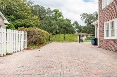 a brick driveway in front of a white fence at LUXURY 6000 sqft Mansion in Downtown Orlando Sleeps 12 in Orlando