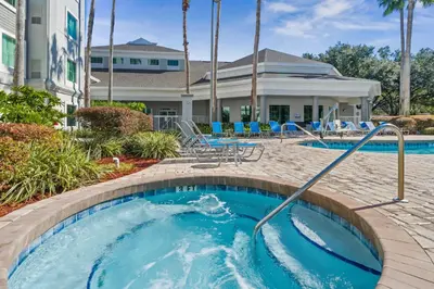 a pool at a resort with blue chairs at DisneyShuttleKing & Queen Be 5 minutes to Disney in Orlando