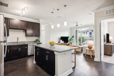 an open kitchen and living room with a large island at The Edge at Millenia in Orlando