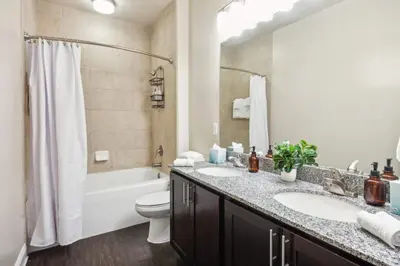 a bathroom with two sinks and a tub and a toilet at The Edge at Millenia in Orlando