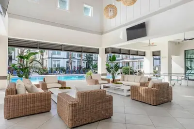 a living room with wicker furniture and a swimming pool at The Edge at Millenia in Orlando