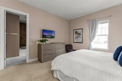 a bedroom with a bed and a bathroom with a window at 5-Suite Disney Escape: Minutes from the Magic in Orlando
