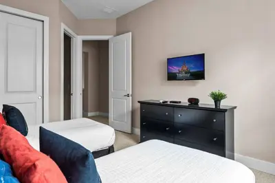 a bedroom with two beds and a dresser at 5-Suite Disney Escape: Minutes from the Magic in Orlando