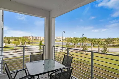 a balcony with a table and chairs and a view of a field at 3191 Paradox Circle 202 in Kissimmee