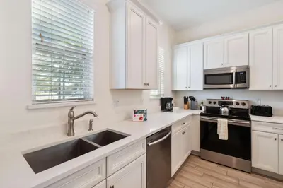 a kitchen with white cabinets and a stainless steel sink at 3050 Pirate Way in Orlando