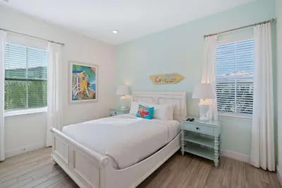 a white bedroom with a bed and two windows at 3050 Pirate Way in Orlando