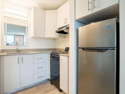 a kitchen with white cabinets and a stainless steel refrigerator at Modern Orlando 1BR Home & minutes to Disney in Kissimmee