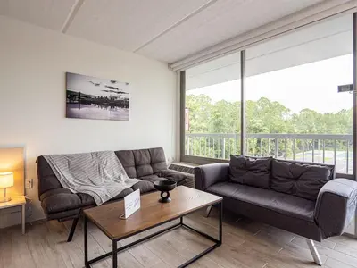 a living room with a couch and a table at Luxury Orlando 1BR Condo with Pool view & Next to Disney in Kissimmee