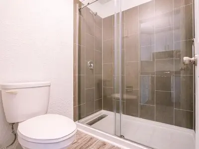 a bathroom with a toilet and a glass shower at Luxury Orlando 1BR Condo with Pool view & Next to Disney in Kissimmee