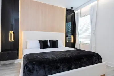 a bedroom with a large white bed with black pillows at Sea World neighbor Deluxe Home Up to 33 ppl 5800 in Orlando