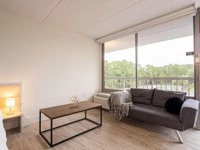 a living room with a couch and a table at Orlando 1BR Condo with lake view & minutes to Disney in Kissimmee