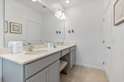 a white bathroom with a sink and a mirror at Brand New 5BedroomsPool LED At Paradiso Grande in Orlando