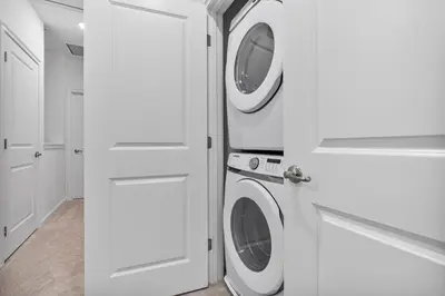 a white laundry room with a washer and dryer at Brand New 5BedroomsPool LED At Paradiso Grande in Orlando