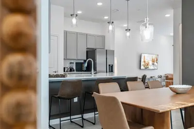 a kitchen and dining room with a table and chairs at Brand New 5BedroomsPool LED At Paradiso Grande in Orlando