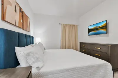 a bedroom with a white bed with a blue headboard at Cozy New 5Bedrooms At Paradiso Grande in Orlando
