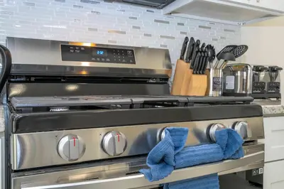 a kitchen with a stove with blue mittens on it at 2024 Coastal Villa 3 suites near Disney in Orlando