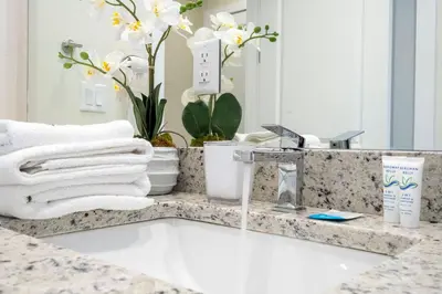 a bathroom sink with white towels and a mirror at 2024 Coastal Villa 3 suites near Disney in Orlando