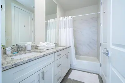 a white bathroom with a sink and a shower at 2024 Coastal Villa 3 suites near Disney in Orlando