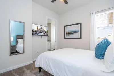 a white bedroom with a bed and a window at 2024 Coastal Villa 3 suites near Disney in Orlando