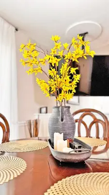 a vase with yellow flowers sitting on a table at Vacation Family Home - Close to Disney in Kissimmee