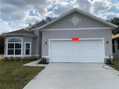 a house with a garage with a red light on it at Sleeps8- WorldCup2026- NearDisney- Universal in Kissimmee