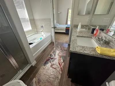a bathroom with a tub and a sink and a shower at Sleeps8- WorldCup2026- NearDisney- Universal in Kissimmee