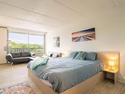 a bedroom with a large bed and a living room at Orlando 1BR comfort With Lake view minutes to Disney Parks in Kissimmee