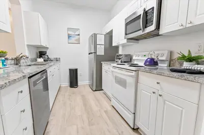 a kitchen with white cabinets and stainless steel appliances at 2304 Silver Palms #205 in Kissimmee