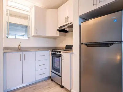 a kitchen with white cabinets and a stainless steel refrigerator at Orlando Paradise 1BR With view & minutes to Disney in Kissimmee