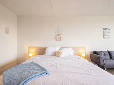 a bedroom with a large white bed and a couch at Peaceful Haven 1BR Next to Disney Parks in Orlando in Kissimmee