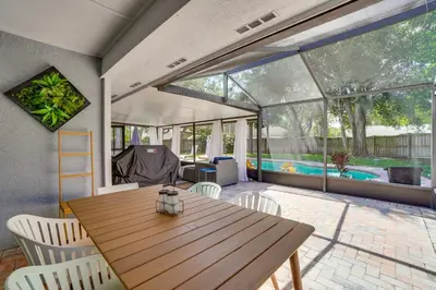 a dining room with a wooden table and chairs at Screened Lanai and Fenced Yard Luxe Orlando Home in Orlando