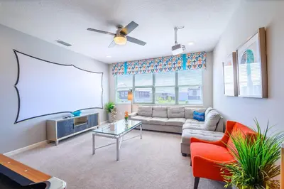 a living room with a couch and a screen at Upstay Sleeps 26 w Private Pool, Hot Tub, Games in Kissimmee