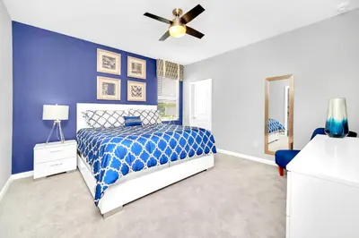 a blue bedroom with a bed and a ceiling fan at Upstay Sleeps 26 w Private Pool, Hot Tub, Games in Kissimmee