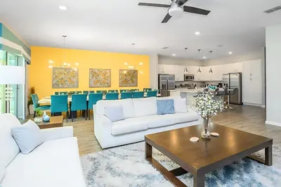 a living room with two white couches and a table at Upstay Sleeps 26 w Private Pool, Hot Tub, Games in Kissimmee