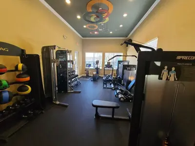 a fitness room with a gym with equipment and aearcher at Modern 4 BR Townhouse near Disney in Kissimmee