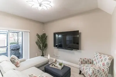 a living room with a couch and two chairs and a tv at Modern 4 BR Townhouse near Disney in Kissimmee