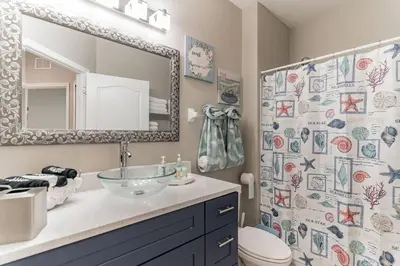 a bathroom with a sink and a toilet and a mirror at Modern 4 BR Townhouse near Disney in Kissimmee