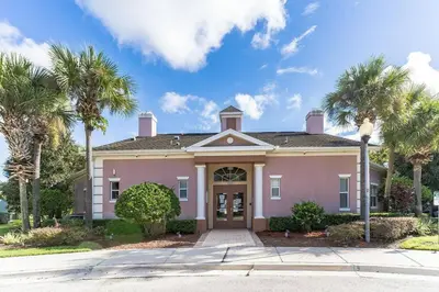 a pink house with palm trees in front of it at Modern 4 BR Townhouse near Disney in Kissimmee