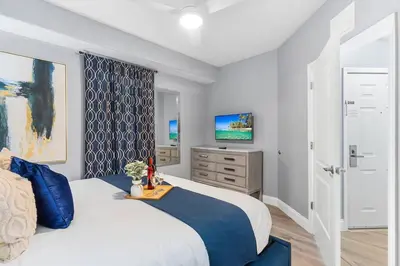 a bedroom with a large bed and a television at Cozy Lakeview Condo near Disney in Orlando