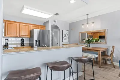 a kitchen with a bar with stools in it at Cozy Lakeview Condo near Disney in Orlando