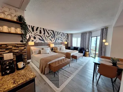 a bedroom with two beds and a living room at Beautiful Zen Nest 1mile New EPIC Universe in Orlando
