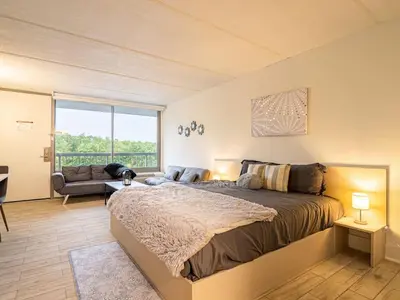 a bedroom with a large bed and a living room at Next to Disney 1BR Retreat in Orlando With Lake view in Kissimmee