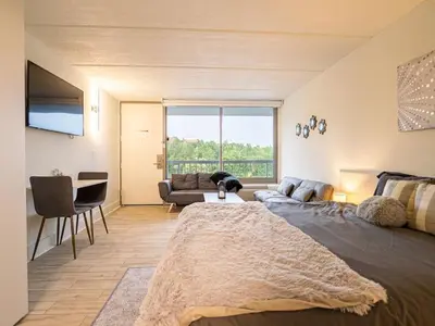 a bedroom with a large bed and a living room at Next to Disney 1BR Retreat in Orlando With Lake view in Kissimmee
