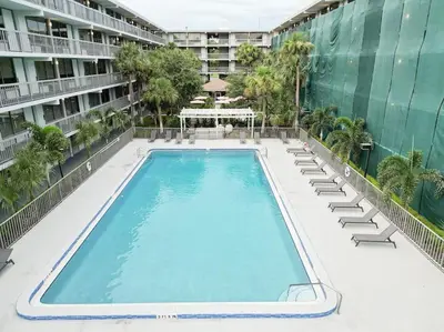 an empty swimming pool with lounge chairs and a building at Next to Disney 1BR Retreat in Orlando With Lake view in Kissimmee