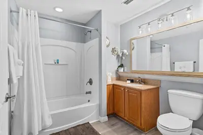 a bathroom with a tub and a toilet and a sink at 5-Min to Disney Lakeside Retreat in Orlando