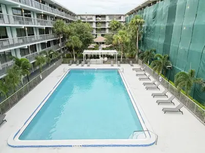 an empty swimming pool with lounge chairs and a building at Vacation 1BR Rental in Orlando & minutes to Disney in Kissimmee