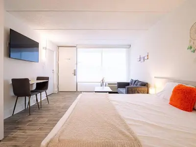 a bedroom with a large white bed and a living room at Vacation 1BR Rental in Orlando & minutes to Disney in Kissimmee