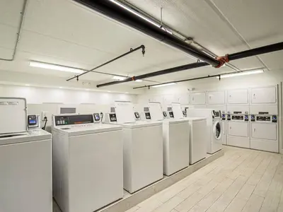 a large laundry room with white washers and dryers at Vacation 1BR Rental in Orlando & minutes to Disney in Kissimmee