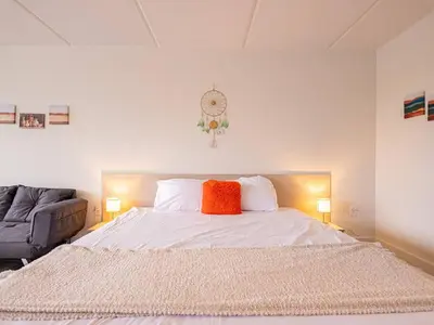 a bedroom with a large white bed with an orange pillow at Vacation 1BR Rental in Orlando & minutes to Disney in Kissimmee