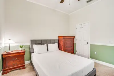 a bedroom with a bed with a wooden dresser and a night stand at Community Amenities at Spacious Orlando Home! in Orlando